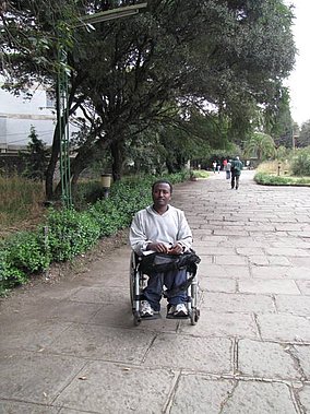 Mamo on AAU campus in wheelchair